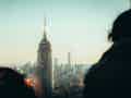 Blick auf die Skyline mit dem Empire State Building, das von zwei Personen im Vordergrund eingerahmt wird.