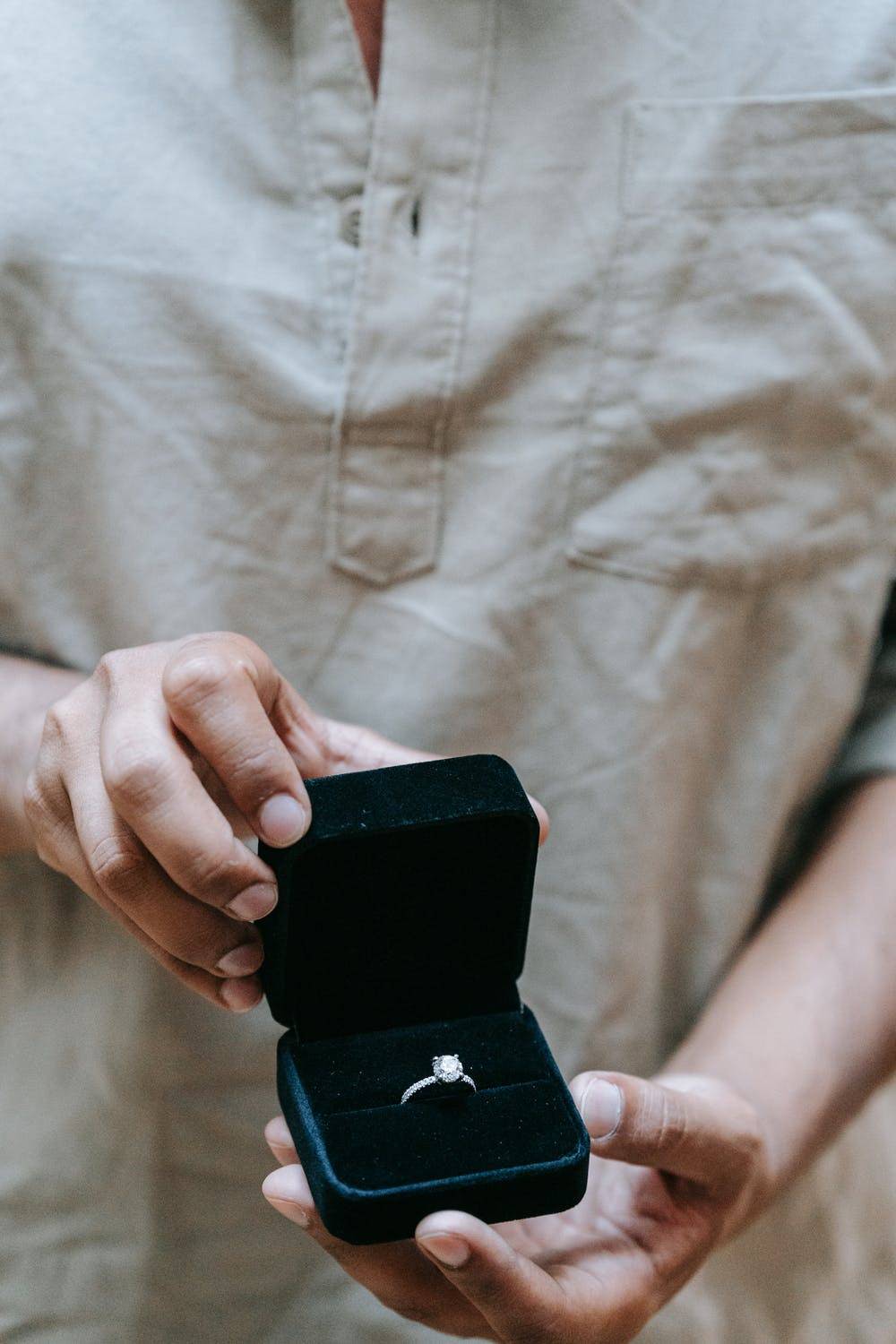 Man holding oval engagement ring in hands 