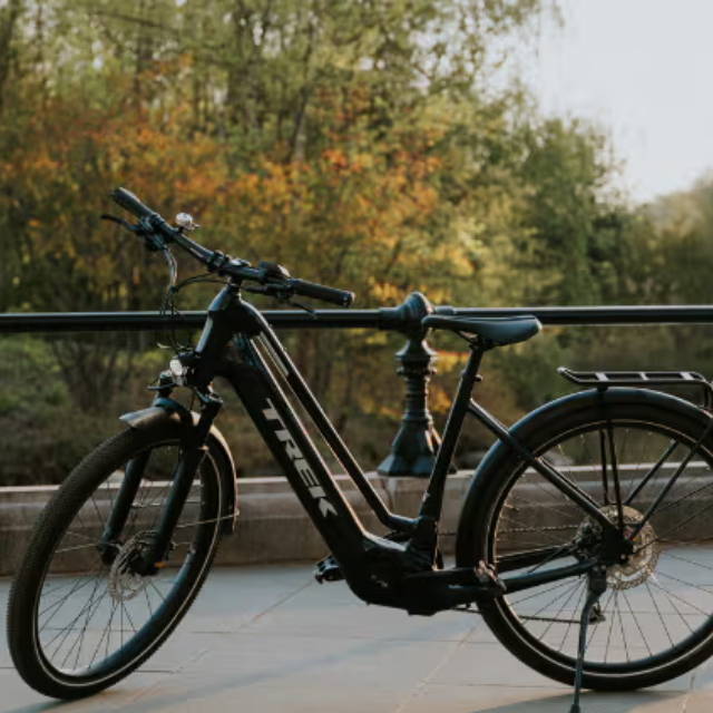 a Trek allant electric city bike on a bike path in front of a pond