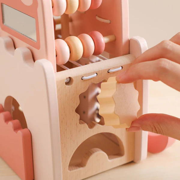 Woman putting a wooden shape inside the Montessori Learning Castle.