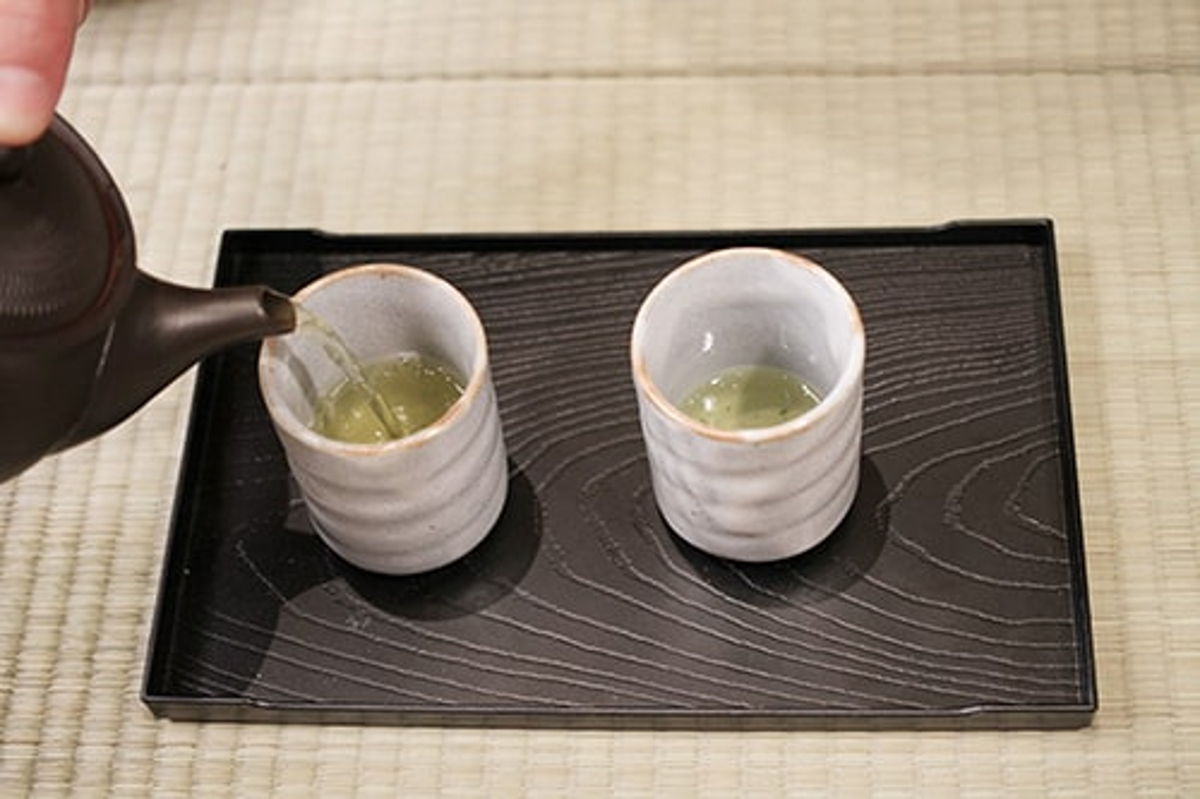 Pour brewed Japanese tea into yunomi cups