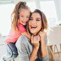 Mother and daughter hugging and laughing.
