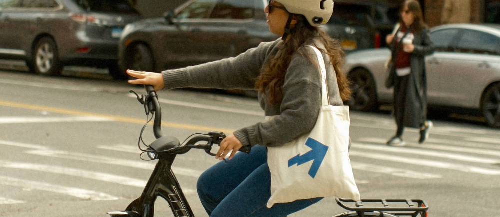 female riding an ebike through NY with an Upway bag on her shoulder