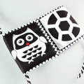 An black and white Owl and a ball printed on the Montessori Newborn Contrast Book. 