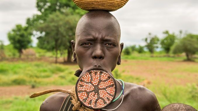 OMO VALLEY, ETHIOPIA - MAY 7, 2015  Woman from the african tribe Mursi with a big lip plate poses for a portrait
