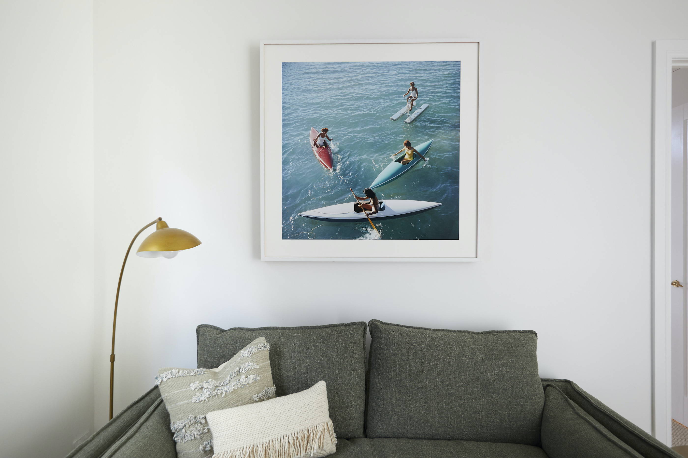 A TV-Mirror hanging on the wall of a coastal, elegant bedroom setting 