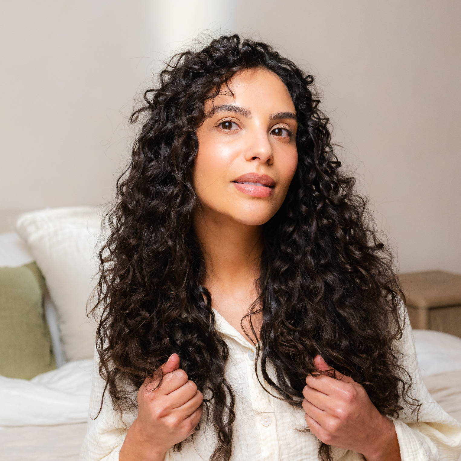 woman scrunching the ends of her dark curly hair