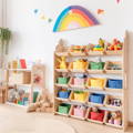 A  beautiful Montessori-inspired playroom with wooden shelves, toys, plush animals, book and a rainbow on the wall. 