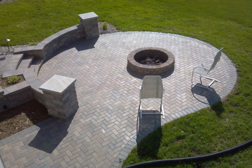 Circular Patio made with Holland Pavers with a fire pit, retaining wall and pillars.