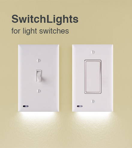 Two lighted switch covers on a yellow wall