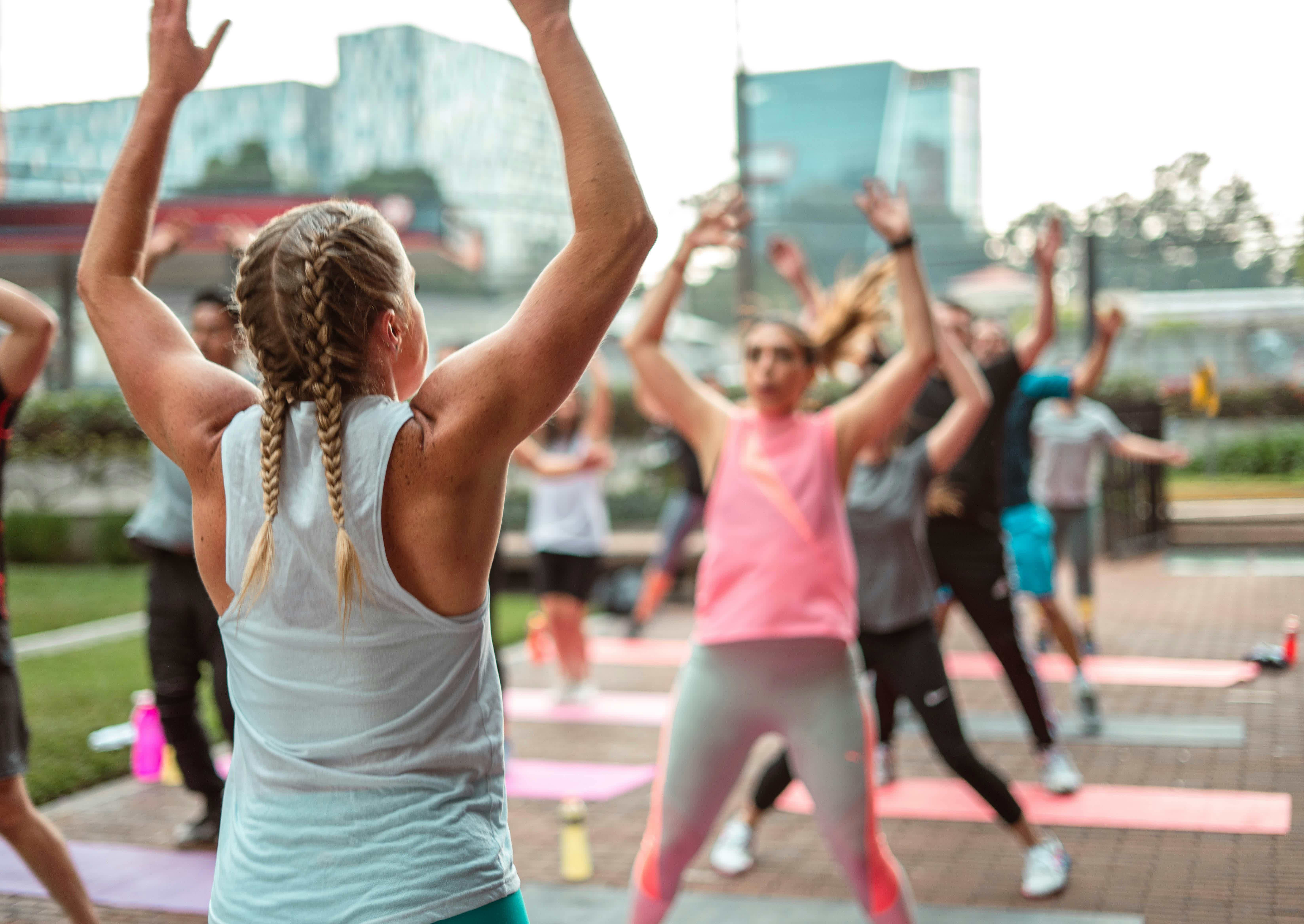 a-group-of-people-doing-yoga-in-a-park-b_4Ospu9B2c