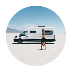 A woman does a handstand in front of a Mercedes 144 Sprinter van with Flarespace flares
