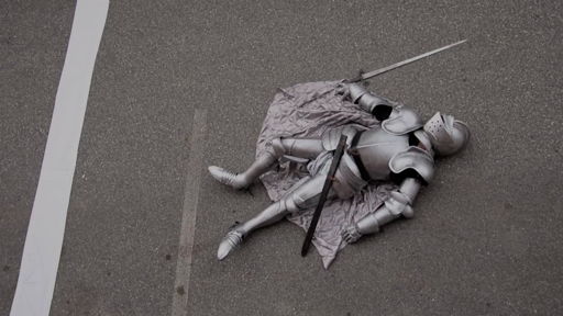 A video thumbnail; a knight in armor, lying in the road.