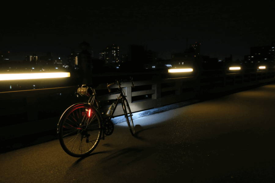 夜間に自転車のライトを付けて走行する人