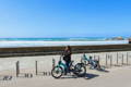 Femme avec son vélo électrique en bord de mer