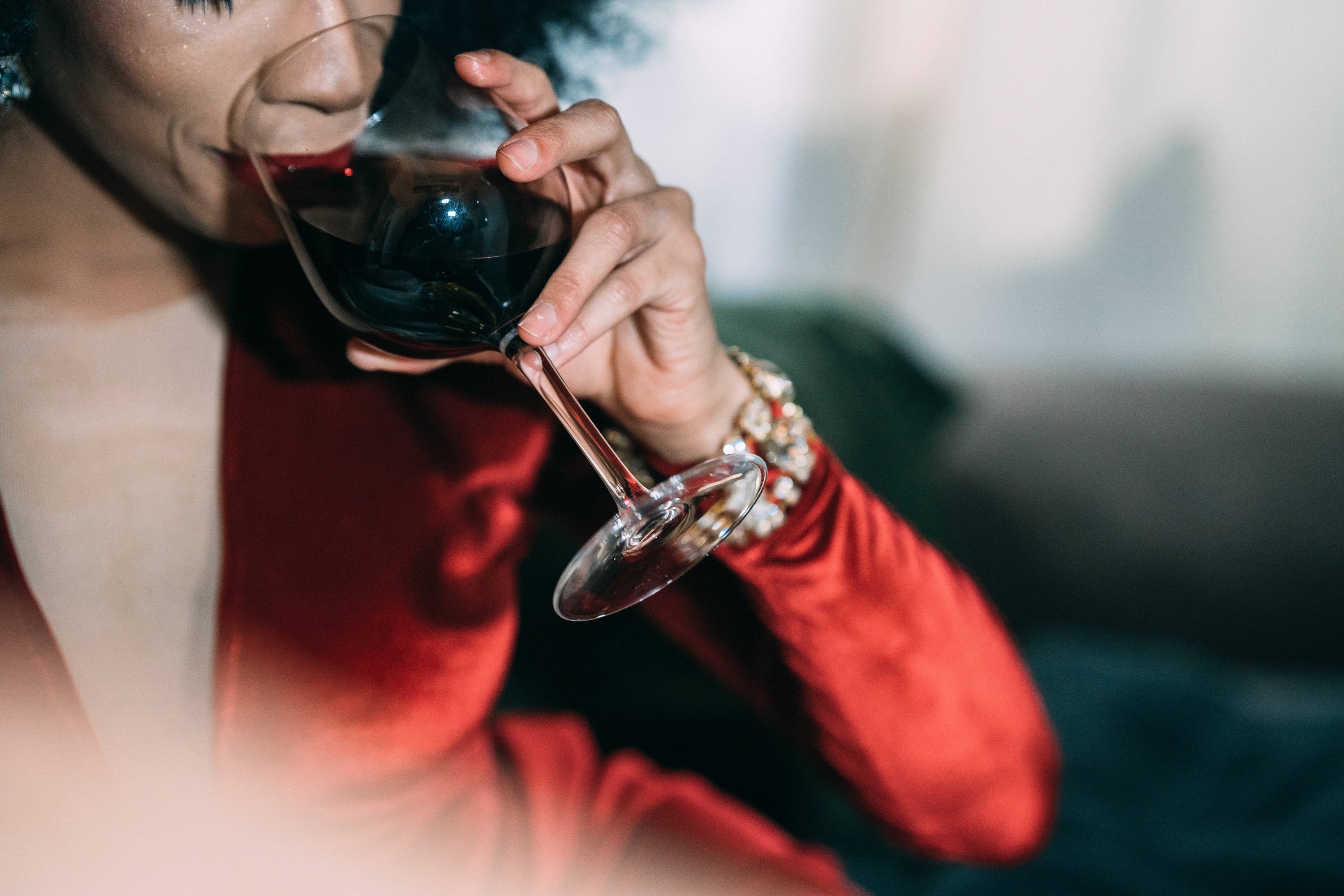 Lady drinking a large glass of full bodied broad red wine. 