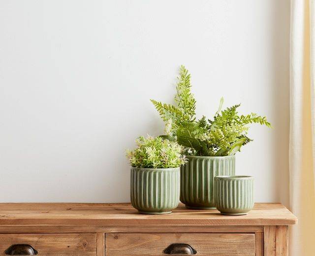 green ceramic vases with artificial ferns