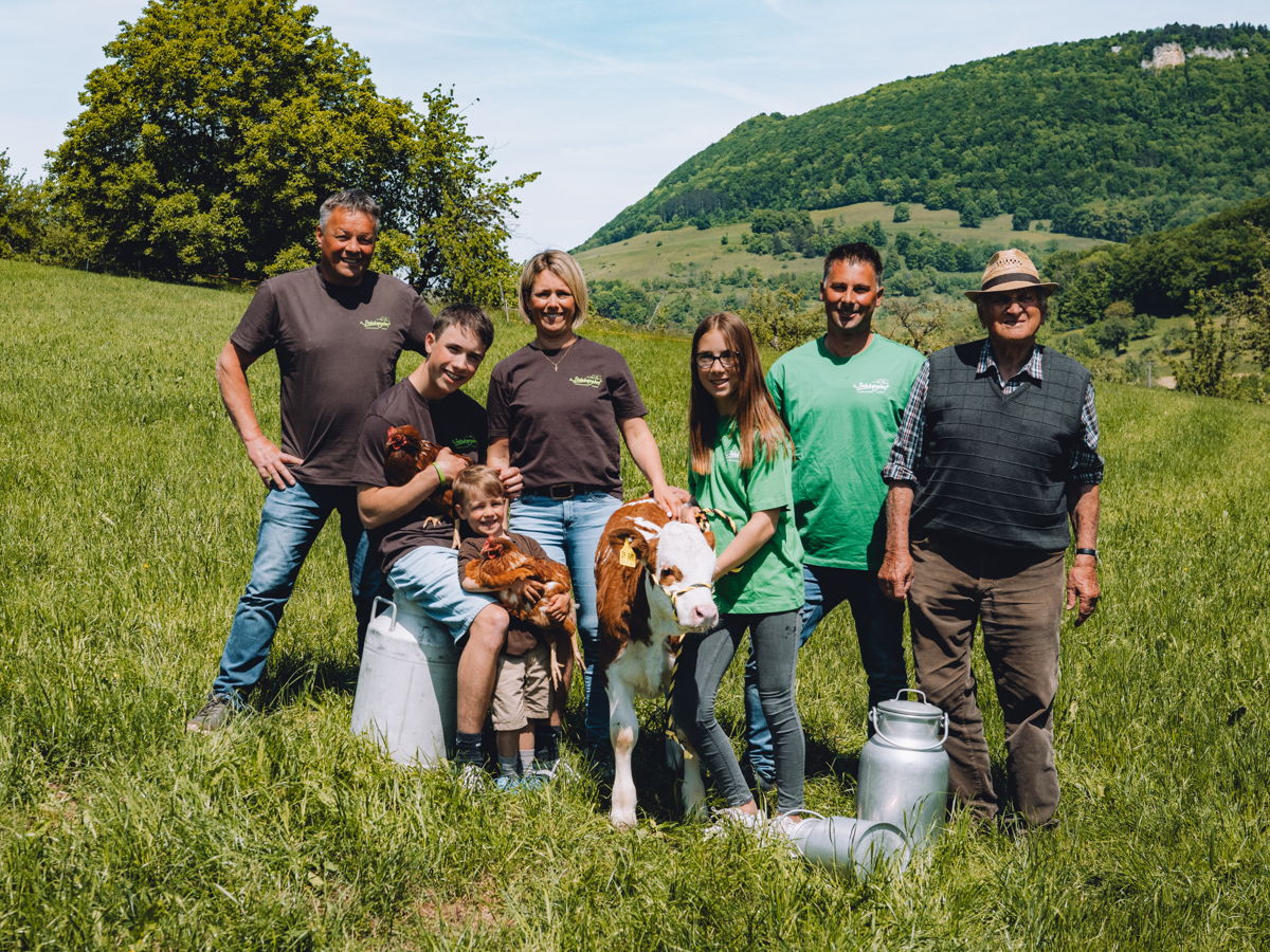Familienbild auf der Wiese von Familie Kuch mit 2 Hühnern und einem Kälbchen