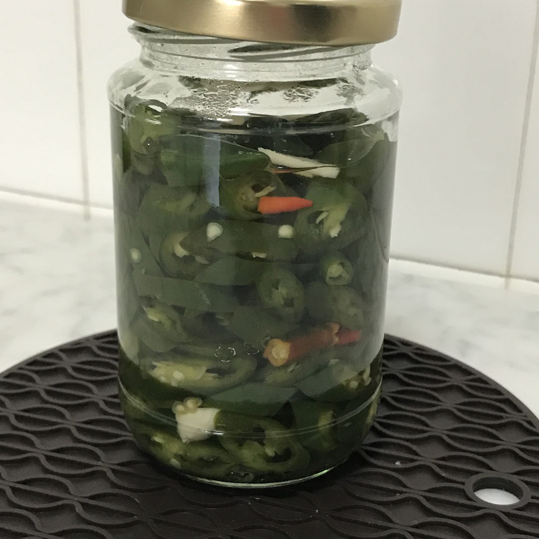 Pickled green chilis with sliced garlic.