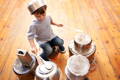 Little boy playing drums improvised using kitchen bowls.