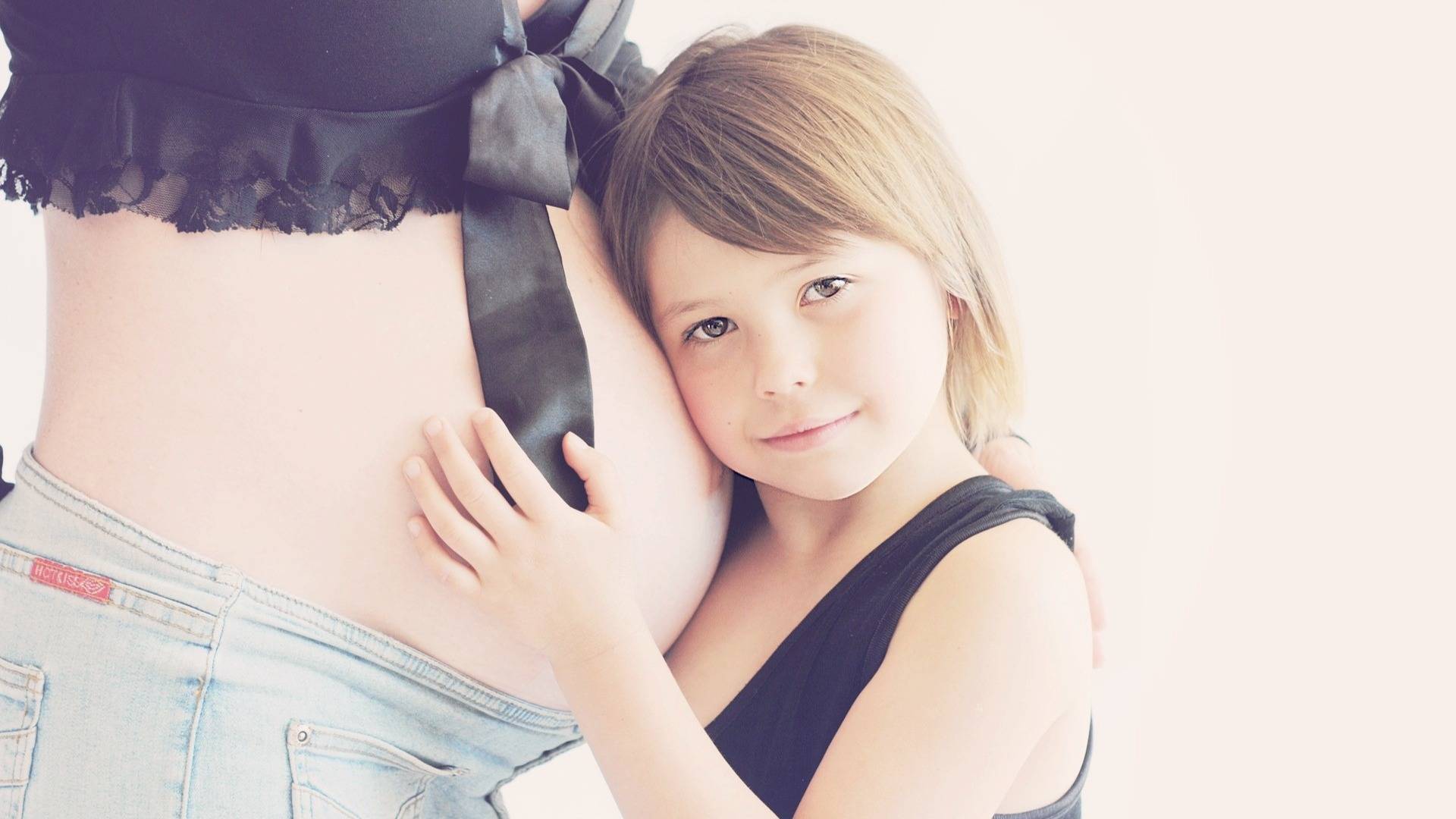 Girl listening to mom's pregnant belly - Lotus Fun