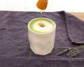 Garden matcha latte in a ceramic cup and honey and lavender on the side on a wooden tray