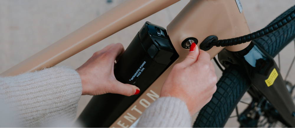 Rider unlocking battery of Aventon Pace 500 e-Bike