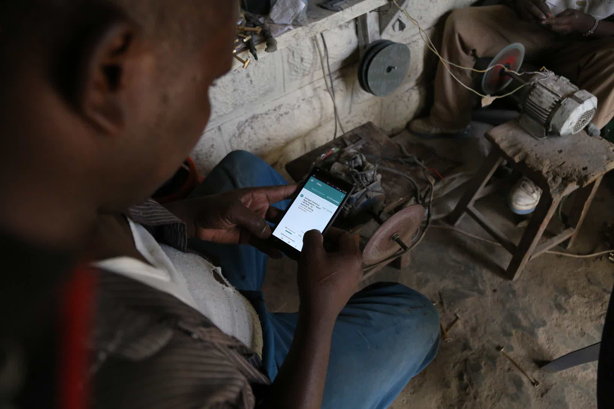 One of SOKO’s artisan partners, Onesmus Ngao, reviews his work order on our proprietary mobile app.