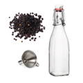 An empty glass bottle with peppercorns and a funnel next to it
