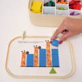 Woman's hand placing a lion puzzle piece onto a wooden board to complete the 5 piece twist matching puzzle game.