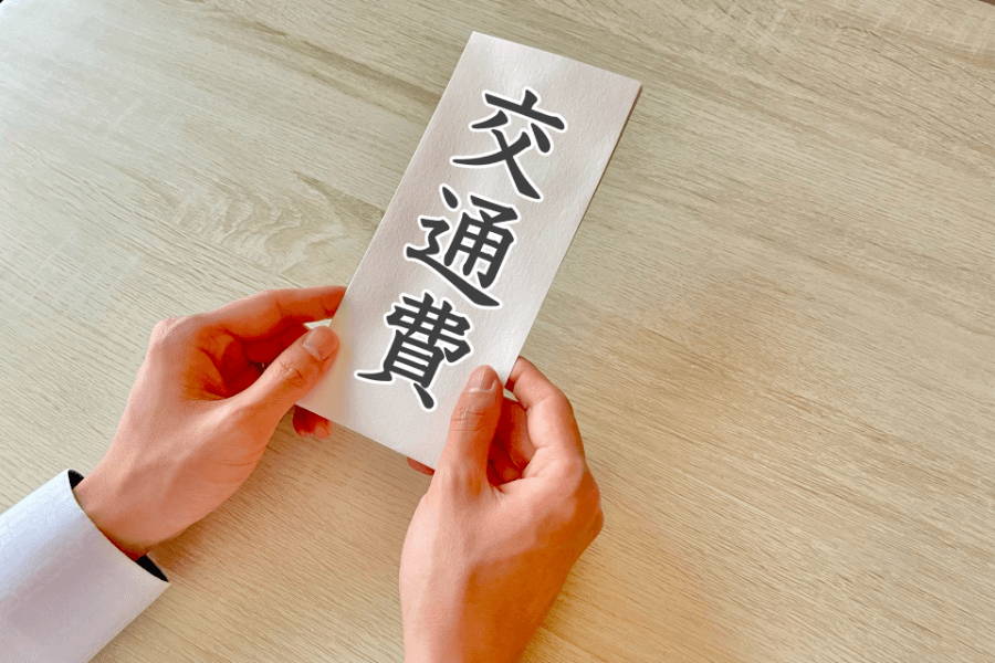 「交通費」と書かれた封筒を持つ手