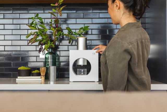Pushing the strength button of the matcha maker.