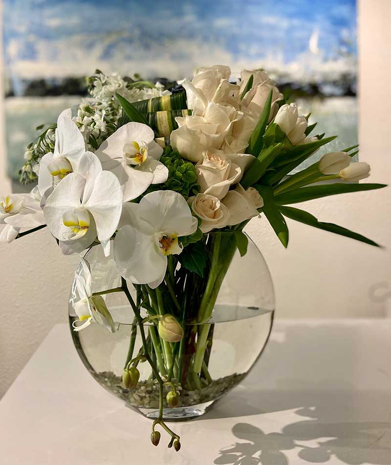 Modern arrangement of white and green in a round glass bowl