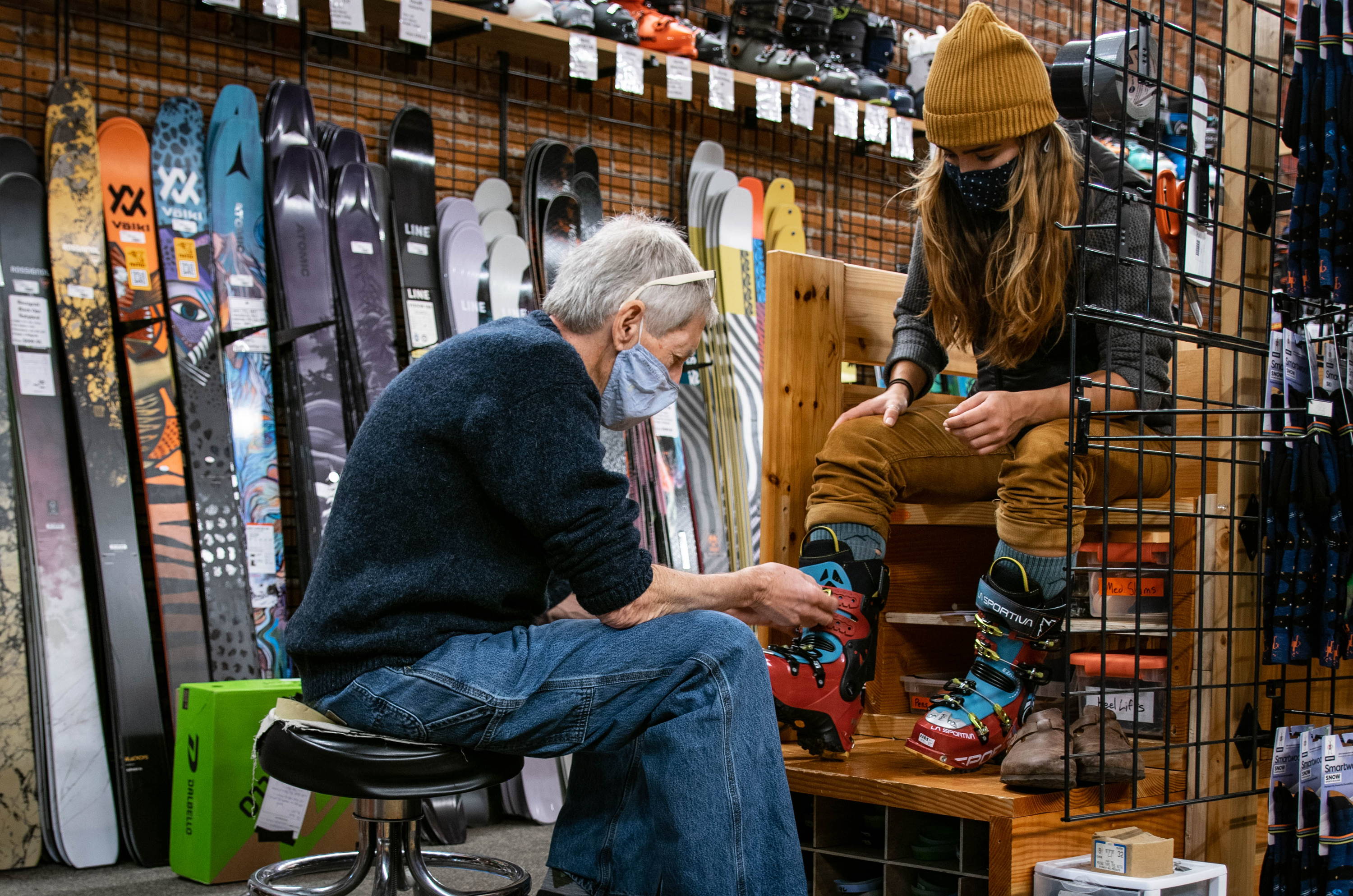 A bootfitter buckling a customer's ski boot.