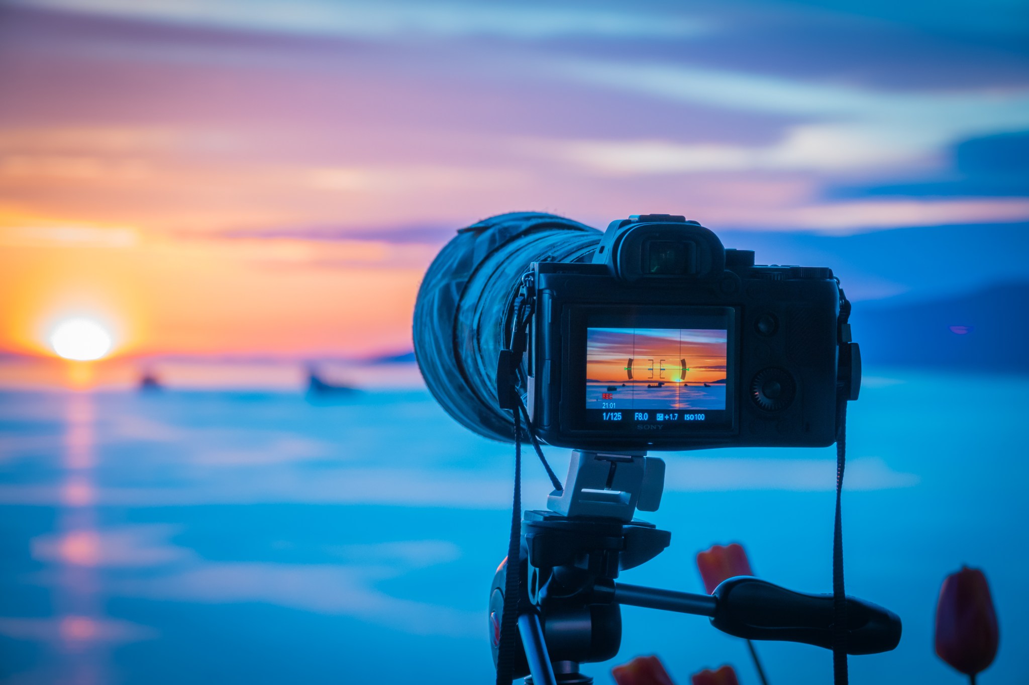 A camera taking a photo of a sunset