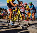 Cycliste sur son velo montant sur la route devant des supporters enthousiastes