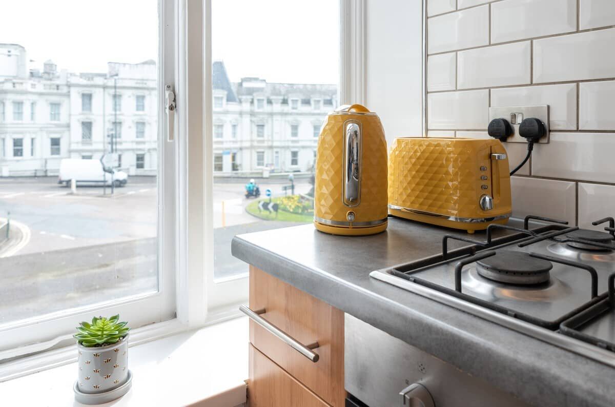 Kitchen showing the kettle and toaster with a large window looking into the courtyard of the property