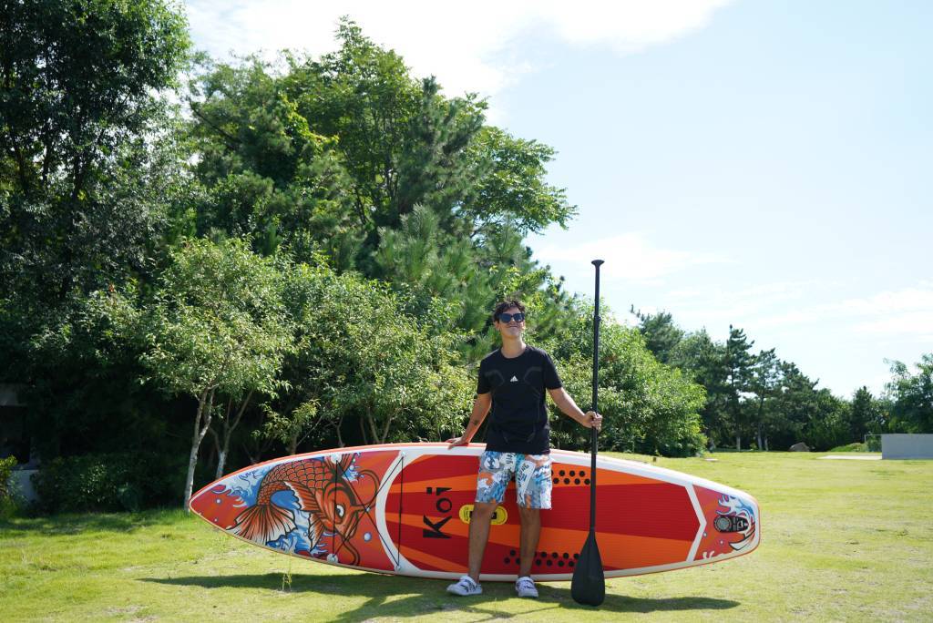 Inflatable paddle board in summer with hat