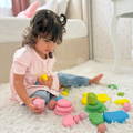 Toddler sitting on a rug and playing with colorful Montessori Stacking Stones.