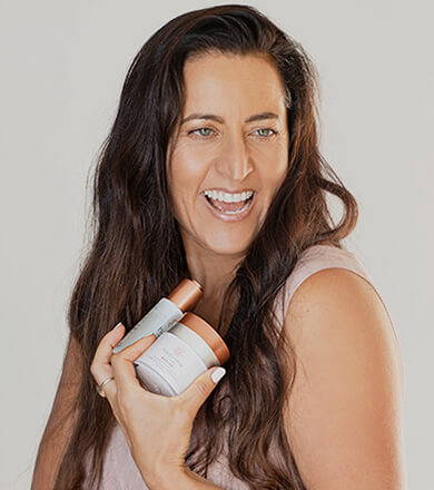 Woman Holding Skin Care Products in Hands and Smiling While Looking Out of Frame - Happy Healthy You