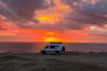 Camper Vans gathered at a campfire at sunset