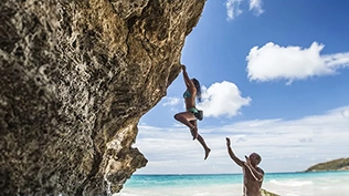 Un couple en train de faire une escalade sur une plage aux Bermudes