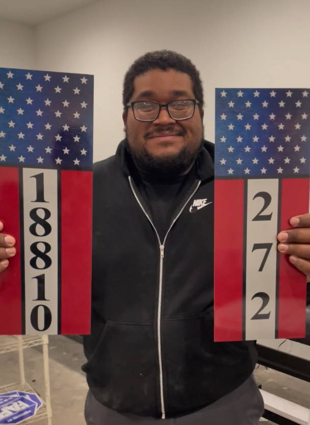 Customer holding metal address sign
