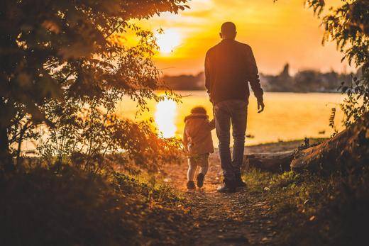 Photo of Father and child walking in the sunset