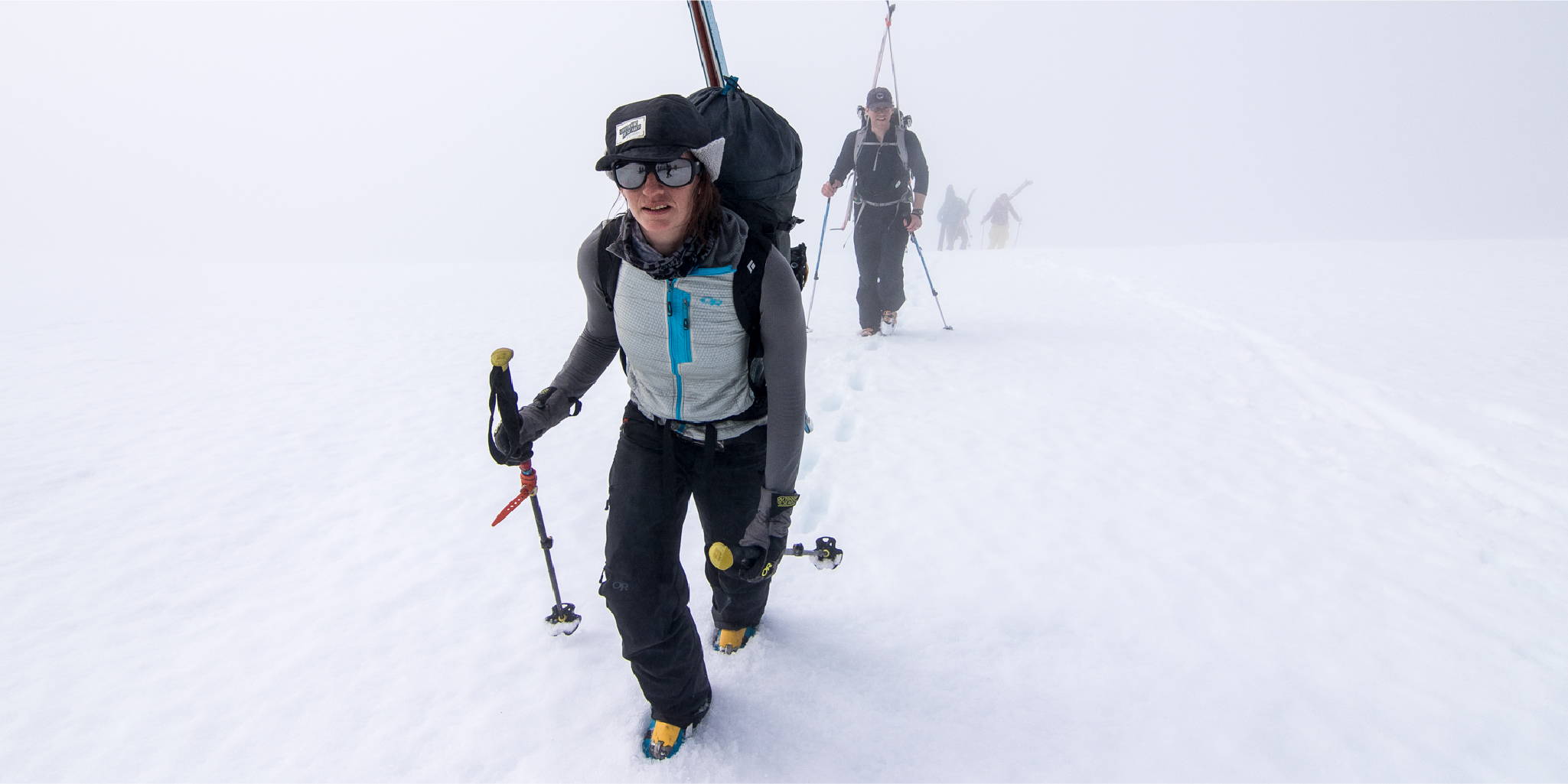 Woman hiking up the snow with her skis
