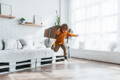 Toddler playing an imaginative screen-free game at home while jumping in the living room