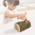 Little girl playing with Montessori Woodpecker toy and placing a worm inside the bird's mouth. 