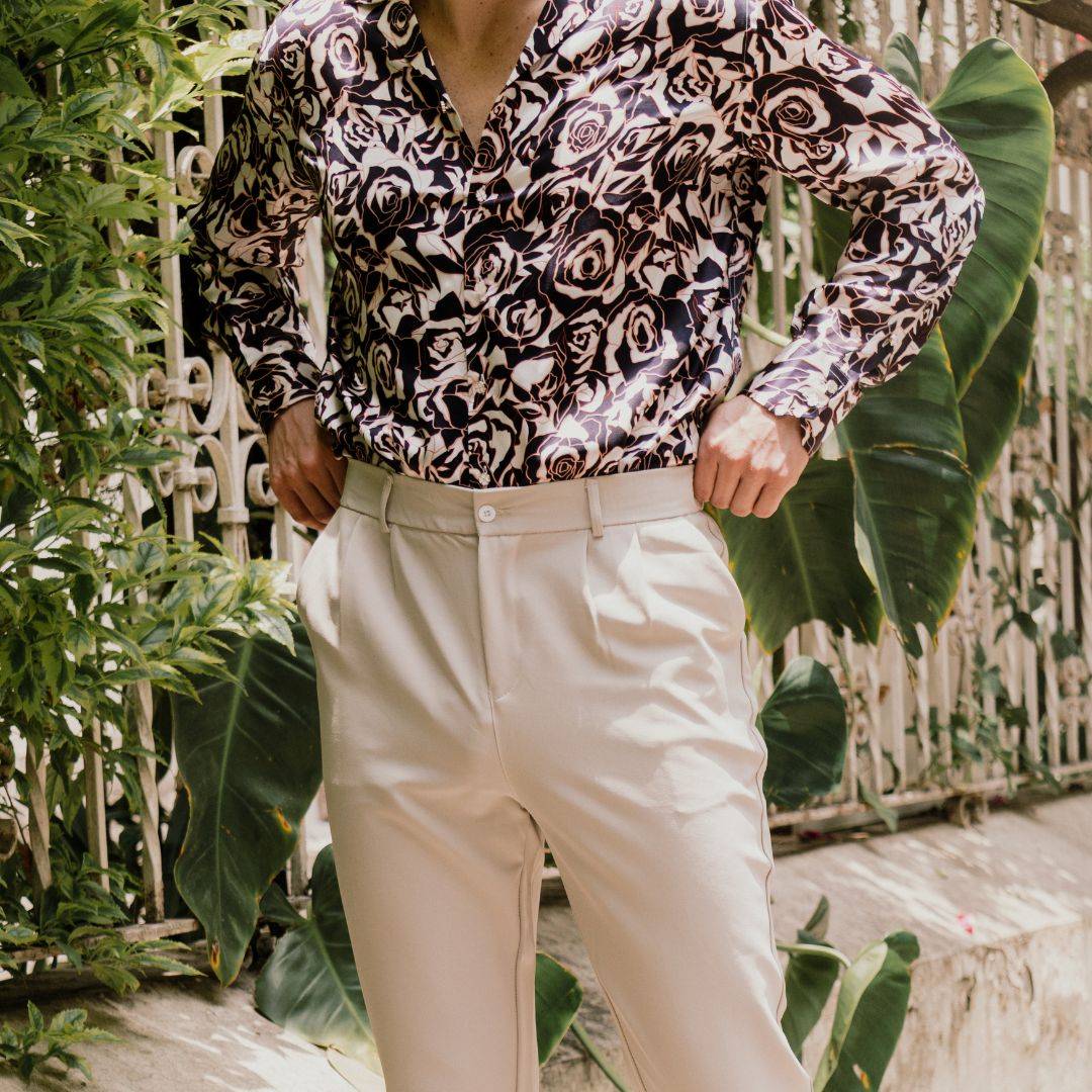 man wearing cream colored pants with a navy rose floral silk shirt from 1000 kingdoms