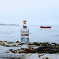 Bouteille de Lussa Gin posée sur une plage près de la distillerie Lussa Gin sur l'île de Jura dans les Hébrides intérieures d'Ecosse