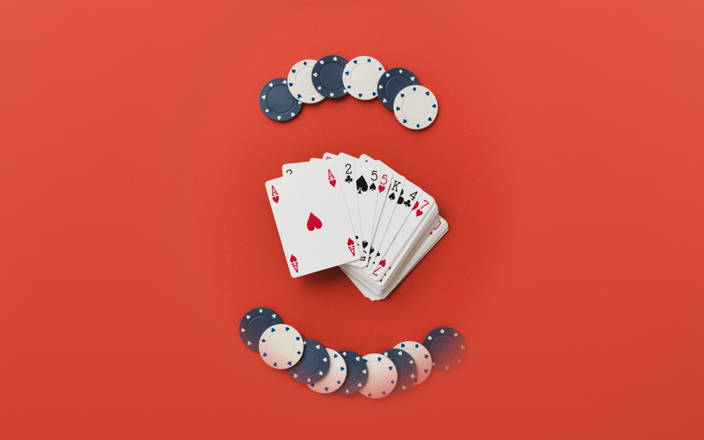 Two stacks of poker chips and a deck of cards spread out on a table for Confetti's Virtual Online Poker for Team Building